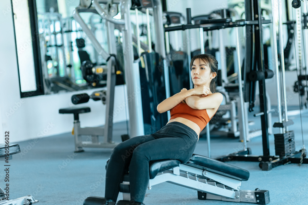 Asian woman in sportswear training sit up at fitness gym. Fitness and workout concept. Asian woman in sportswear training sit up at fitness gym. Fitness and workout concept.