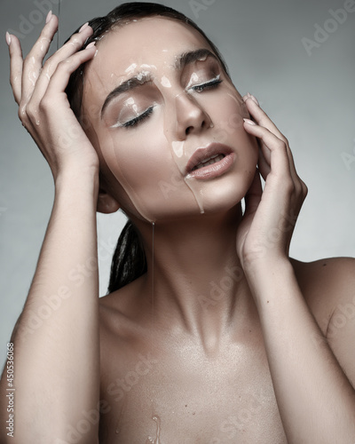 Close up portrait of wet young girls face. Drops of water running on her face. Her mouth half opened. Skin care concept
