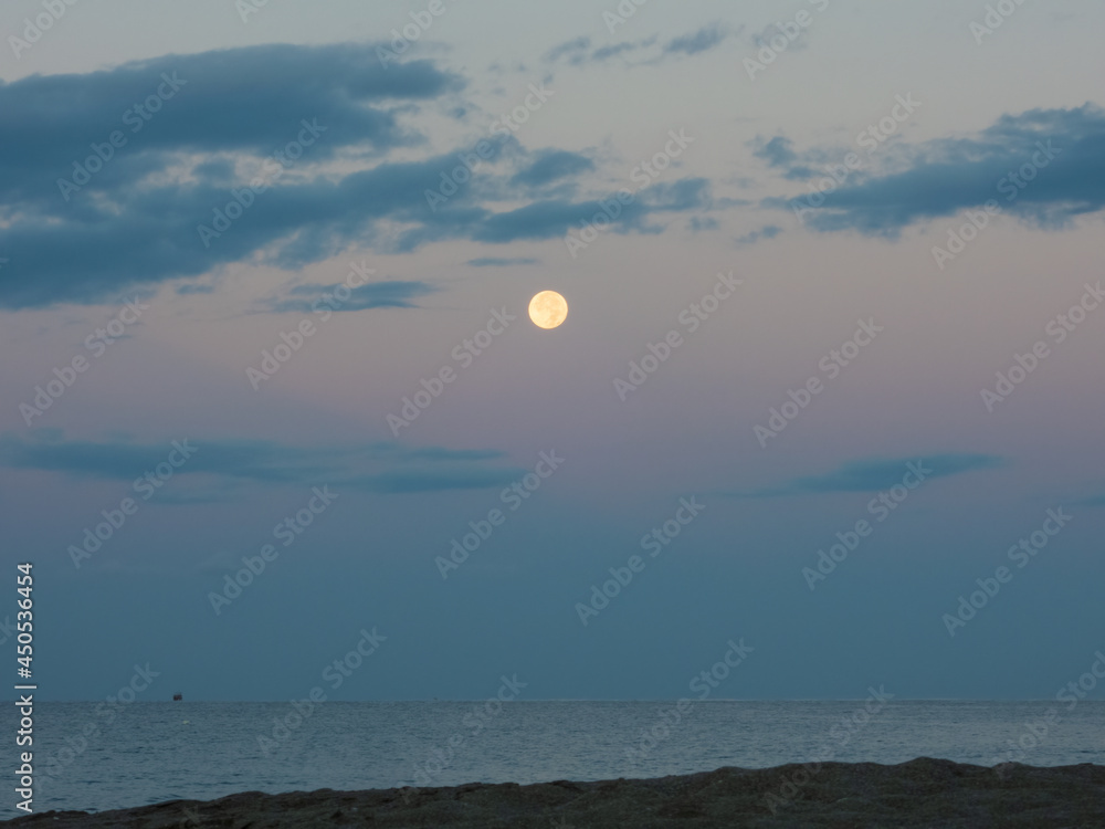 Full moon in the dawn sky. Early morning on the sea Full moon in the dawn sky. Early morning on the sea