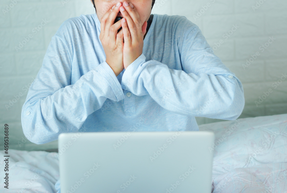 Look at the laptop, startled, excited, put his hand over his mouth. Look at the laptop, startled, excited, put his hand over his mouth.
