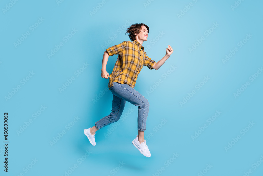 Profile photo of carefree sporty lady jump run fast wear plaid shirt jeans sneakers isolated blue color background