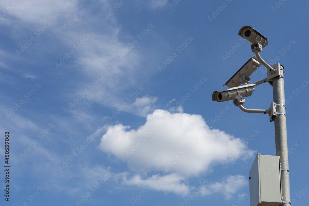 Group security cctv cameras in front of blue sky.