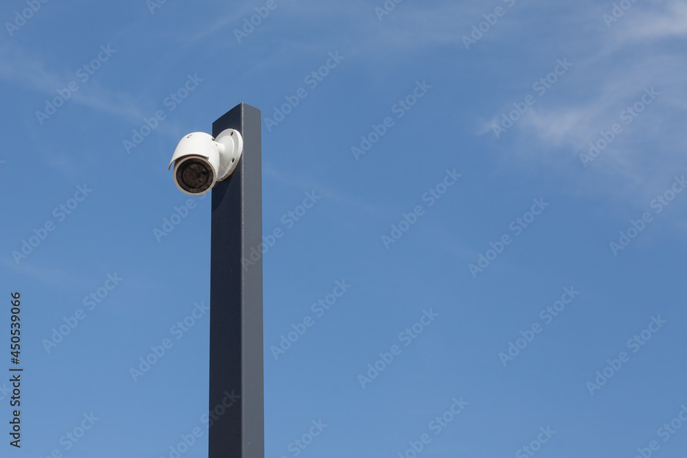 Singiel white modermSecurity cctv cameras in front of blue sky. Singiel white modermSecurity cctv cameras in front of blue sky.