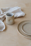 ceramic cup and plates on a wooden table top view. minimalist set of handmade ceramic tableware and pottery