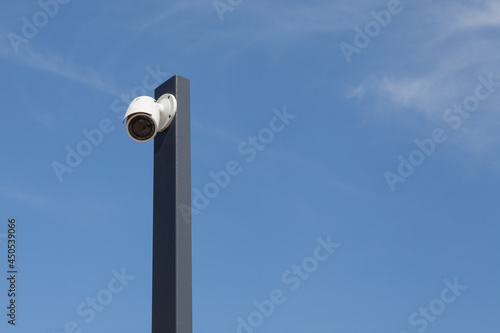 Singiel white modermSecurity cctv cameras in front of blue sky. photo