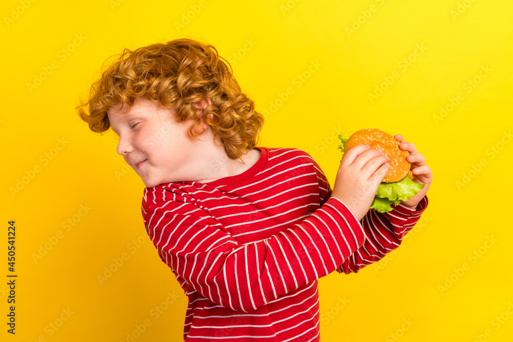Photo of young addicted small little boy hold hands burger refuse diet food isolated on yellow color background