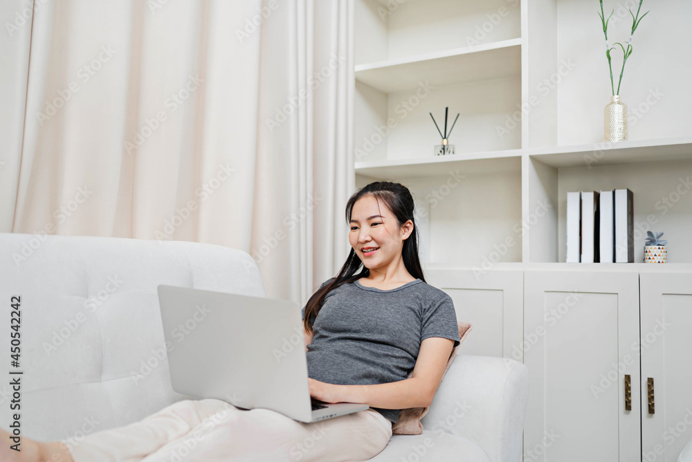 Work at home young asian woman working on laptop computer while sitting at the living room. working from home while in quarantine isolation Work at home young asian woman working on laptop computer while sitting at the living room. working from home while in quarantine isolation