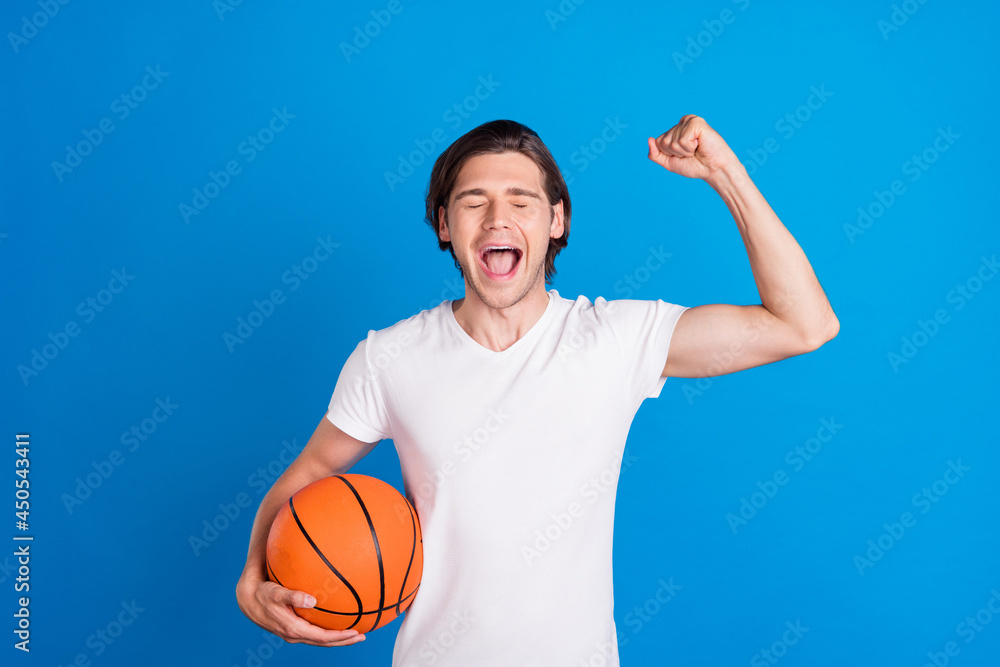 Photo portrait brunet man keeping ball gesturing like winner wearing white t-shirt isolated vivid blue color background