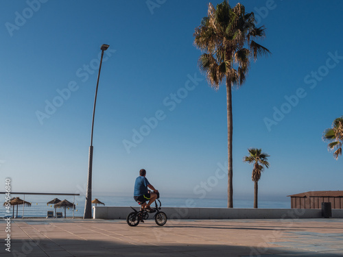 Young man with electric bike on the promenade of estepona, Costa del Sol