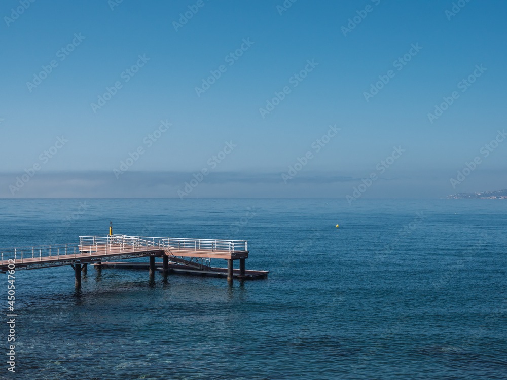 Lonely pier by the sea and clear sky. Peaceful scene and with copy space