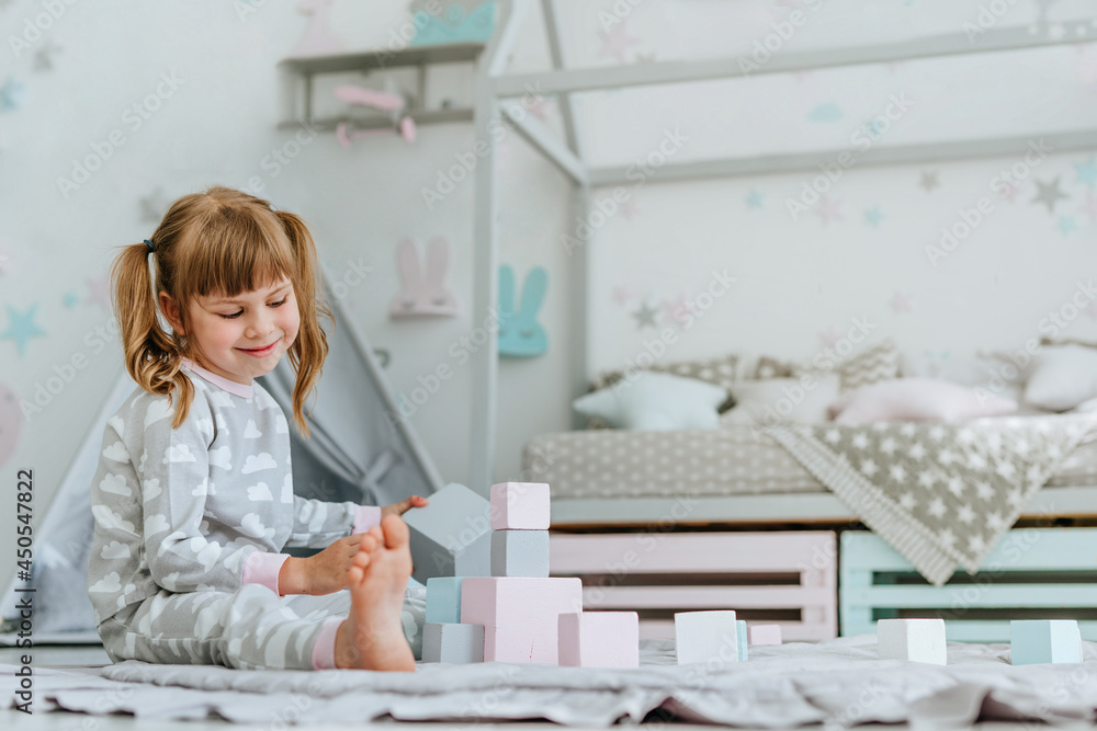 Beautiful little girl playing with wooden toy blocks Beautiful little girl playing with wooden toy blocks