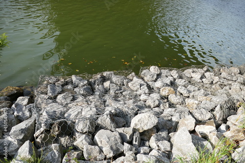 Slope stabilization of an artificial waterway Midland Canal  Mittellandkanal  in Germany by using natural stones and wire mesh. Hannover  Lower Saxony  Germany. 