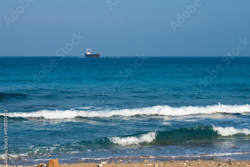 three waves near the shore. a blurred ship on the horizon. Sea waves, water tide. seascape. Raging sea waves. Selective focus. High quality photo