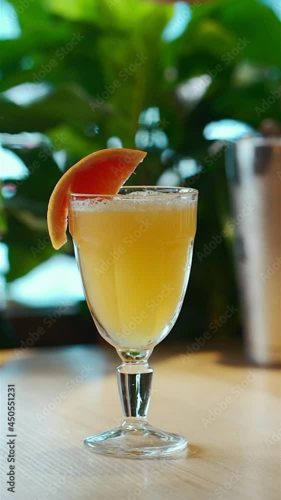 hand decorate yellow tropical cocktail with grapefruit slice in glass goblet hand decorate yellow tropical cocktail with grapefruit slice in glass goblet