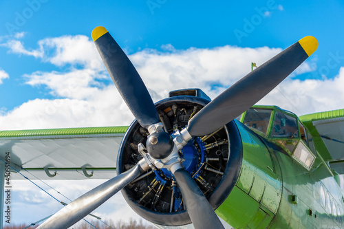 The propeller and engine of an old Soviet biplane on the background of the sky and clouds.Retro light airplane at the airport in nature. Air transportation of passengers and cargo.