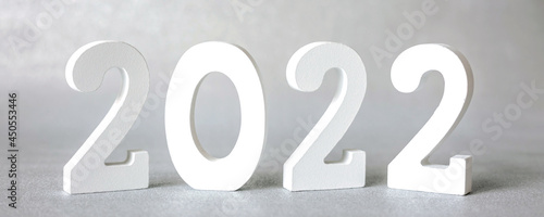 Decorative white wooden numbers 2022 isolated on grey background. Happy new year 2022. Banner