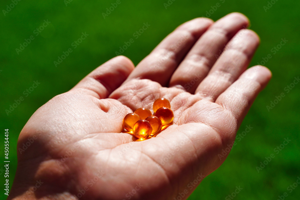 Top view on woman's hands holding pile of capsules Omega 3 Top view on woman's hands holding pile of capsules Omega 3