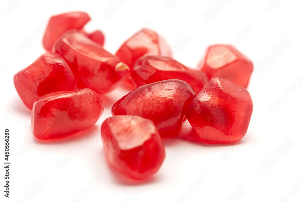 Micro Close-up of organic red pomegranate seed (Punica granatum) isolated over white background.