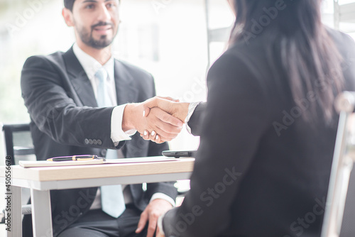 Business man shake hands with business women agreeing on partnerships or introducing themselves for first time meet photo