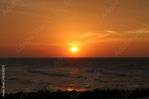 Atardecer en la playa puesta de sol en el mar con cielo naranja