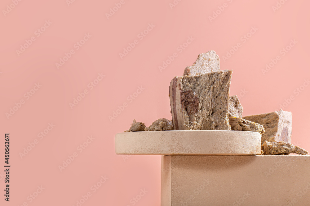 Pieces of halva on modern beige circle and square podium for product on pastel background. Traditional dessert on cube pedestal. Horizontal orientation, side view, copy space. Pieces of halva on modern beige circle and square podium for product on pastel background. Traditional dessert on cube pedestal. Horizontal orientation, side view, copy space.