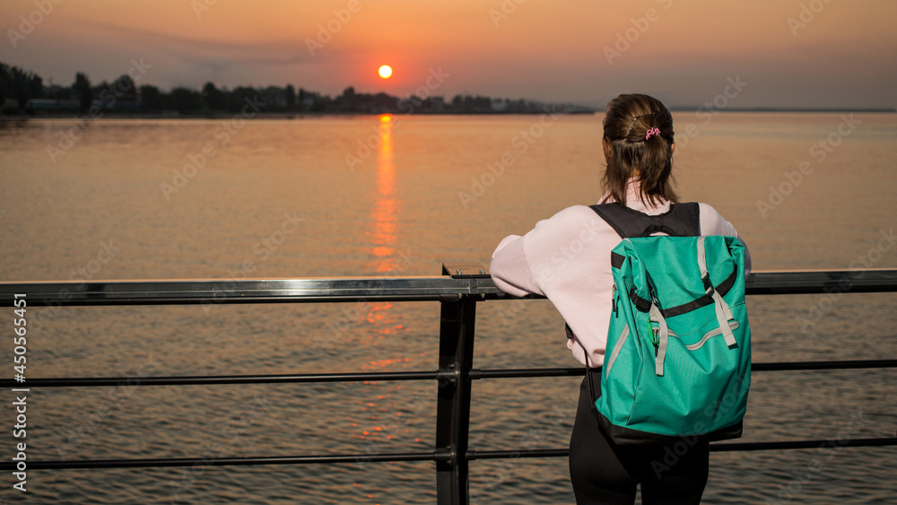 Happy traveler watching sunrise or sunset in the sea