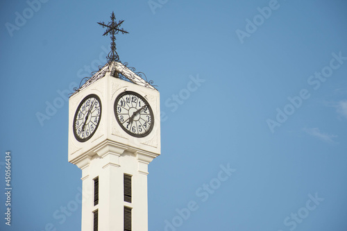  White tower with an analog clock to be seen from afar.
