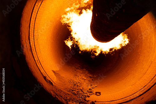 Close up of flame in rotary kiln during heating mode in cement plant photo