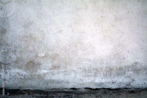 old white wall covered with dirty plaster with a visible structure