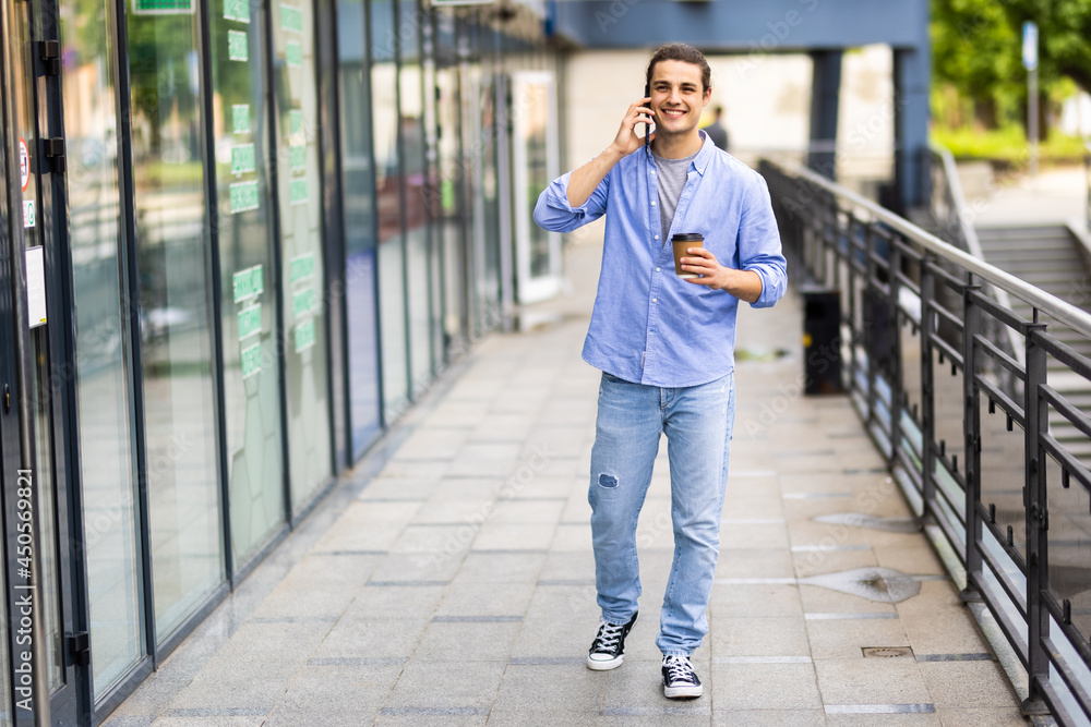 Young man talk on phone and walk on street