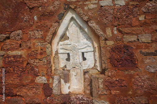 Cross crucifix inserted in the wall of the Transfiguration Church (Tserkov Spasa na Kovalyove), close to Veliky Novgorod. Novgorod Oblast, Russia. photo