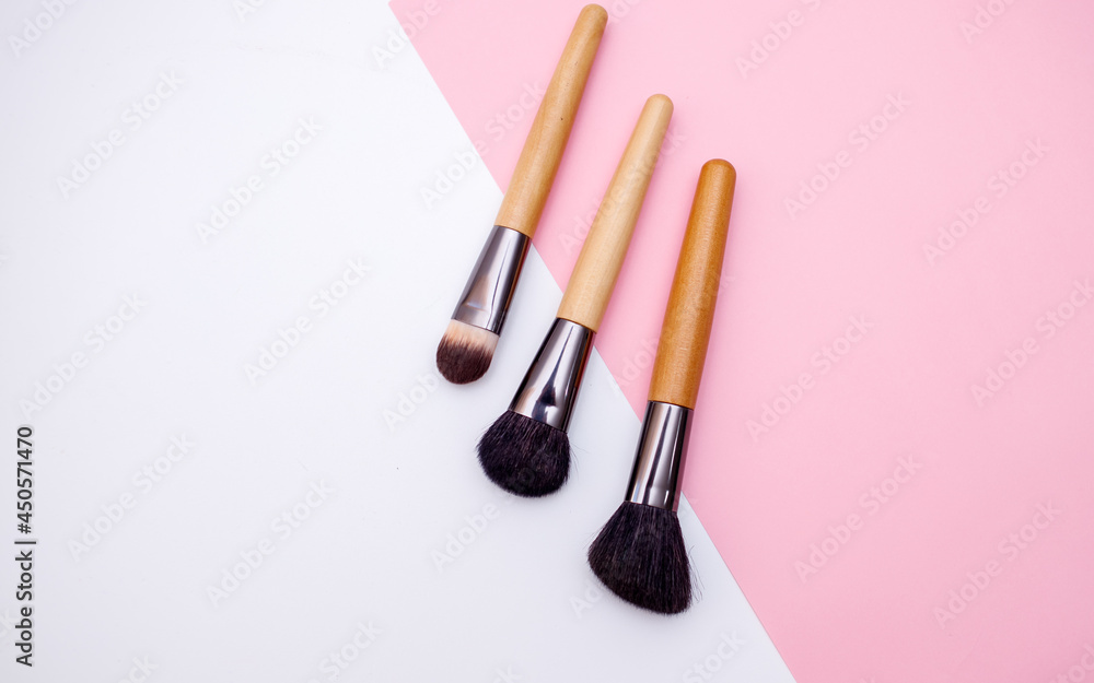 A set of professional brushes for makeup and face correction lies on a colored background with copy space for text A set of professional brushes for makeup and face correction lies on a colored background with copy space for text