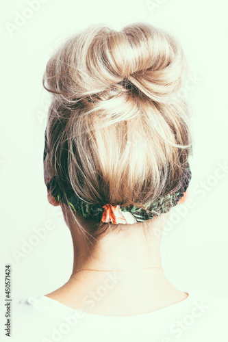 blonde girl with a bun of hair on her head, back view