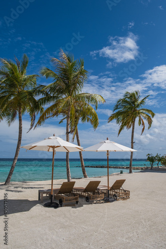 Beautiful landscape with sunbeds and umbrellas on the sandy beach  Maldives island. Crossroads Maldives  saii lagoon. July 2021