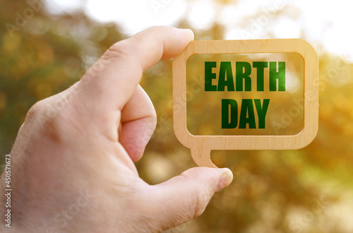 A man holds a sign inside which the inscription - earth day