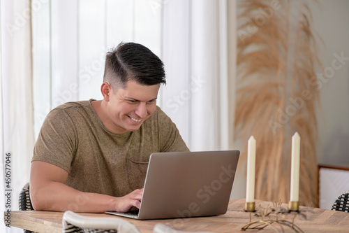 Young Adult using a laptop at the kitchen table