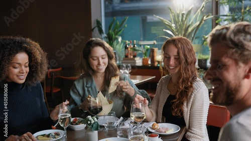 Slow motion of friends enjoying dinner in restaurant