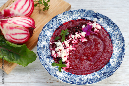 Beetroot puree soup sprinkled with beetroot chips and feta cheese crumbs photo