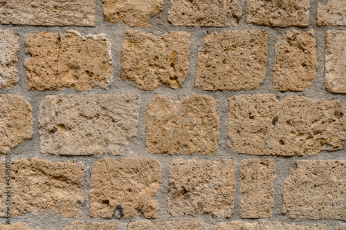 Photo Wall made with many tuff bricks. Wall of tuff stone.