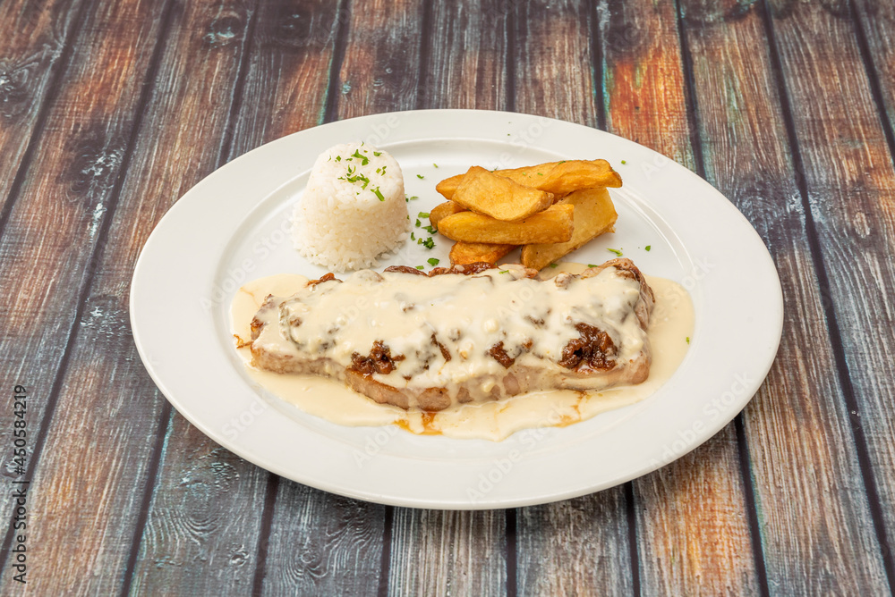 steak with pepper slathered in sauce garnished with homemade fries and a bowl of white rice steak with pepper slathered in sauce garnished with homemade fries and a bowl of white rice