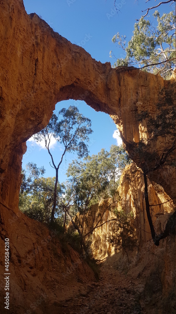 Arch Over Golden Gully at Hill End New South Wales Australia. Eroded gully sides and Australian Eucalyptus Trees. Dry River Bed