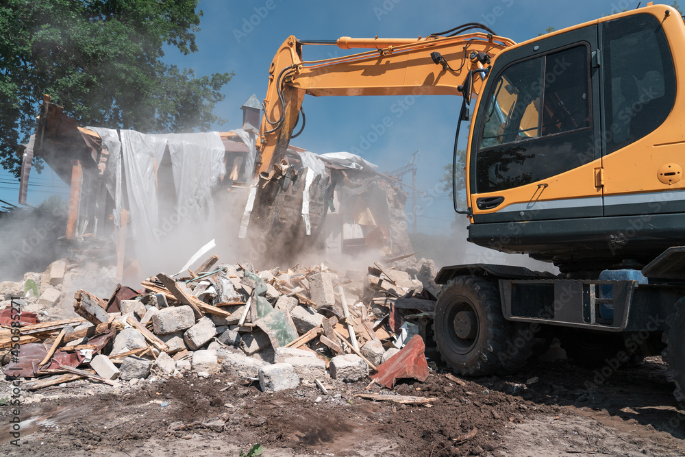 House demolition. Big yellow excavator breaks building for new construction. House demolition. Big yellow excavator breaks building for new construction.