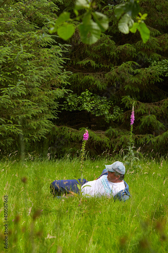 A caucasian disability man resting in the bright green fresh forest.