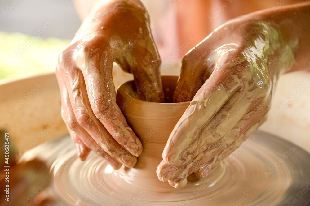 Creative process of making pottery on her own using a special wheel