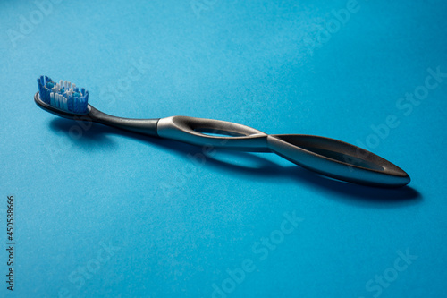 modern aluminum toothbrush on a light blue surface