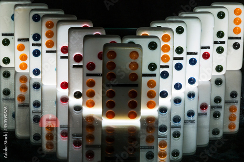Peças de dominó em sequencia sobre a superfície de um espelho. photo