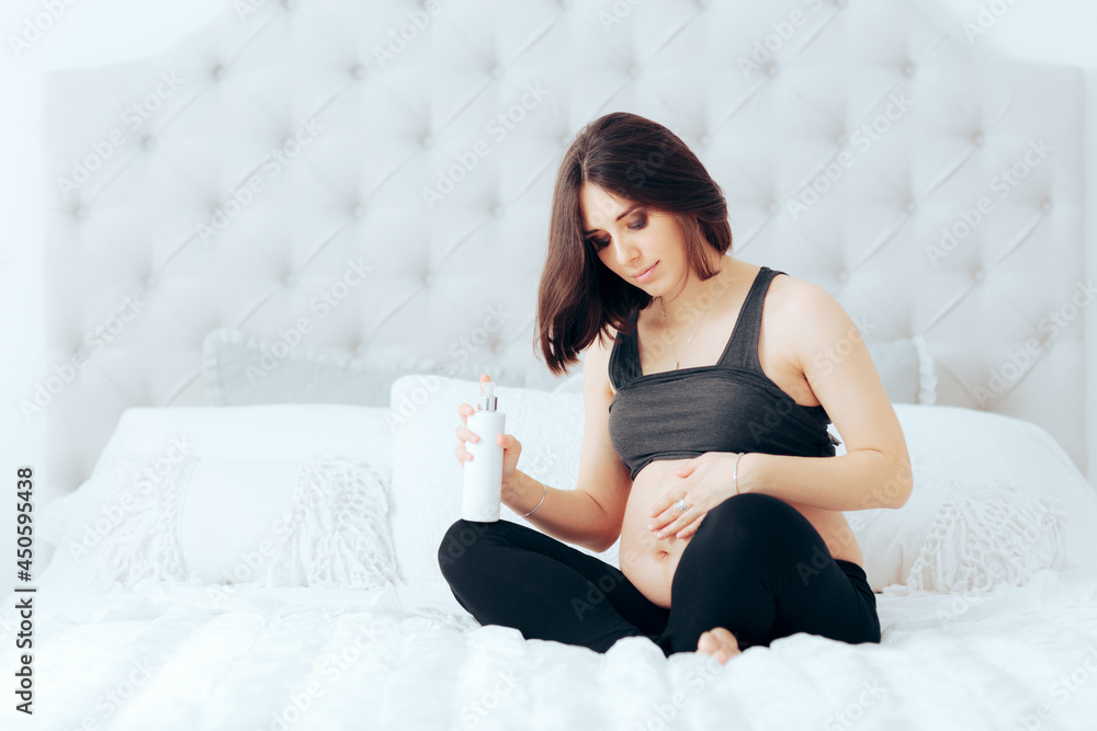Pregnant Woman Rubbing Cream Anti-Stretchmarks on her Stomach Pregnant Woman Rubbing Cream Anti-Stretchmarks on her Stomach