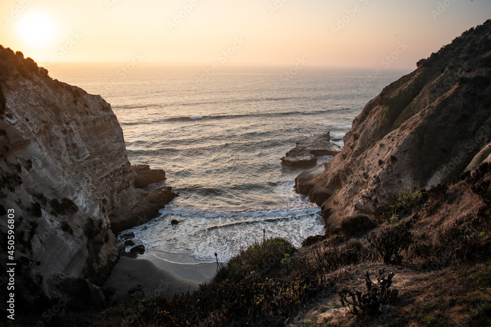 A secret beach between big cliffs on a beautiful sunset