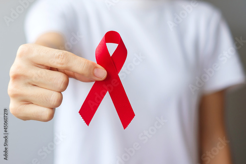 Фотография Hand holding Red Ribbon for December World Aids Day (acquired immune deficiency syndrome), multiple myeloma Cancer Awareness month and National Red ribbon week