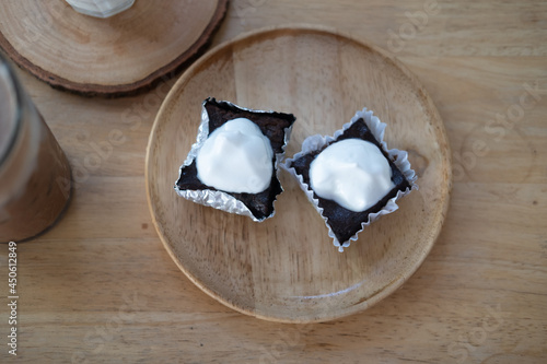 Mini chocolate brownies decoration with whipped cream in a foil cup